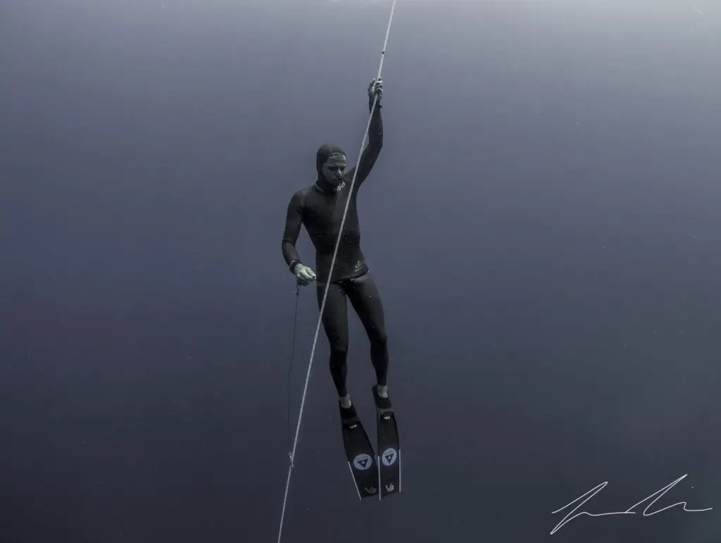 Thibault, deep freediver, hanging underwater on one breath.